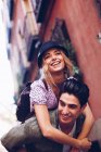 Junger fröhlicher Mann gibt Frau Huckepack-Fahrt während Dating im Freien — Stockfoto