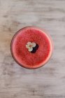 Bubble frothy tasty fragrant pink smoothie decorated with flower in glass on grey shabby surface — Stock Photo