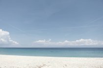 Pintoresca playa tranquila con nubes en el horizonte y playa de arena blanca en el día soleado, Halkidiki, Grecia - foto de stock
