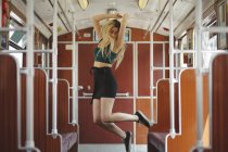 Young blonde woman jumping in train car in Berlin — Stock Photo