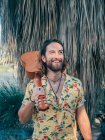 Pensive bearded hipster man traveling in jungle with ukulele — Stock Photo