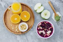 De laranjas servidas acima, amendoim e suco de laranja na mesa com maçãs, condimentos e tigela de beterraba — Fotografia de Stock