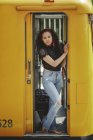 Young cheerful beautiful hispanic woman standing on yellow train in drivers cabin in Berlin looking at camera — Stock Photo