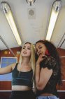Queridas mujeres multirraciales en el coche de tren de Berlín mirando a la cámara - foto de stock