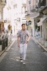 Красивий щасливий чоловік в гавайській сорочці ходьба на вулицю, поглянувши — стокове фото
