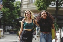 Junge schöne, gut gelaunte Frauen laufen an einem Sommertag auf der Berliner Straße — Stockfoto