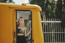 Jovem alegre bela loira mulher de pé no trem amarelo na cabine motoristas em Berlim olhando para a câmera — Fotografia de Stock