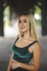 Schönes blondes Model lächelt und blickt in Berlin auf verschwommenem Hintergrund in die Kamera — Stockfoto