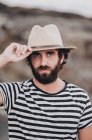 Bearded male in hat on deserted road, portrait — Stock Photo