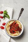 Köstliche Conchiglie-Pasta mit Basilikum und roter Tomatensauce auf weißem Teller — Stockfoto