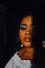 Portrait de belle jeune femme noire incurvée avec un maquillage lumineux en robe hors épaule regardant la caméra — Photo de stock