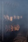 Fileiras de peixes eviscerados pendurados em cordas de cozinhar dentro fumeiro — Fotografia de Stock