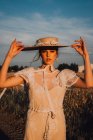 Woman in big round hat in middle of wheat field — Stock Photo