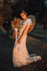 Жінка в сукні з квітковим букетом — стокове фото