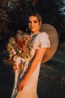 Femme en robe avec bouquet de fleurs — Photo de stock