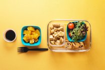 Plastic containers with healthy food and black fork — Stock Photo