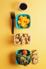 Contenants en plastique avec aliments sains et fourchette noire — Photo de stock