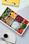Scatola degli alimenti con ingredienti dietetici per copybook e piatto — Foto stock