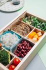 Boîte à aliments contenant des ingrédients diététiques par cahier et assiette — Photo de stock