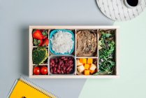 Caixa de alimentos com ingredientes dietéticos por copybook e placa — Fotografia de Stock