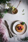 Вкусный блин со свежей малиной и мятными листьями на белой тарелке на мраморном столе — стоковое фото