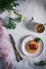 Вкусный блин со свежей малиной и мятными листьями на белой тарелке на мраморном столе — стоковое фото