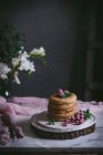 Pila di frittelle di lampone con bacche fresche su piatto di porcellana su sfondo scuro — Foto stock