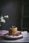 Стек малинових млинців зі свіжими ягодами на порцеляновій тарілці на темному фоні — стокове фото