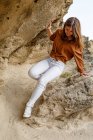 Mulher aventureira bonita em jeans brancos que andam em pedras rochosas no deserto — Fotografia de Stock