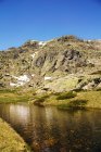 Petit lac au fond d'une montagne rocheuse avec neige en Sierra de Guadarrama Espagne — Photo de stock