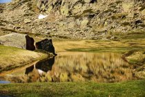 Small lake at bottom of rocky mountain with snow in Sierra de Guadarrama Spain — Stock Photo