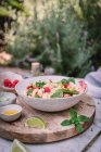 Von oben appetitanregender Salat und Sauce Beeren Limettenscheiben auf Holzständer mit Salz und Pfeffer auf dem Tisch — Stockfoto