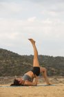 Metà donna adulta con i piedi fino a fare yoga all'aperto sulla spiaggia diga — Foto stock