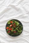 Bowl of healthy salad with fresh ripe chard on wrinkled white fabric — Stock Photo