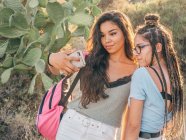 Sonrientes mujeres jóvenes de moda tomando selfie en el campo - foto de stock