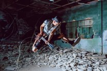Musician playing electric guitar in abandoned place — Stock Photo