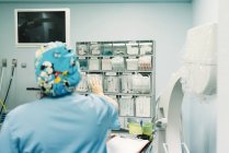 Rückenansicht einer Sanitäterin in blauer Uniform, die Hilfsgüter für Operationen im Krankenhaus nimmt — Stockfoto