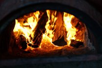 Fogo ardente brilhante quente com no forno na escuridão — Fotografia de Stock