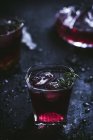 Carafe et verres en cristal remplis de glace et de vin rouge sur table noire — Photo de stock