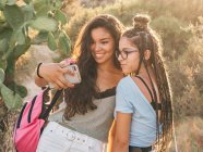Smiling trendy young women taking selfie at countryside — Stock Photo