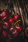 Leckere appetitlich reife gewaschene Kirschen in Schale auf dunklem Holztisch — Stockfoto