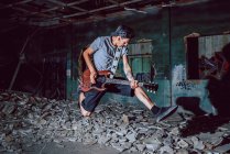 Musicista che suona chitarra elettrica in luogo abbandonato — Foto stock