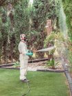 Fumigatore in sostanza spray uniforme bianca sul giardino — Foto stock