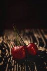 Вкусные аппетитные спелые вишни на темном деревянном столе — стоковое фото