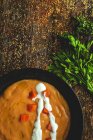 Von oben wohlriechende Gemüsecremesuppe mit geschnittener reifer Karotte und Petersilie auf Holzgrund — Stockfoto
