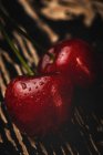 Вкусные аппетитные спелые вишни на темном деревянном столе — стоковое фото