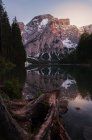 Paisaje de estanque redondo en el césped verde exuberante que refleja el cielo y las montañas en Dolomitas, Itlay - foto de stock