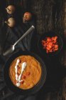 Dall'alto gustosa zuppa di crema vegetale profumata con carota matura tagliata e cipolle su fondo di legno — Foto stock