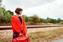 Молода жінка, що стоїть на вокзалі в сільській місцевості — стокове фото