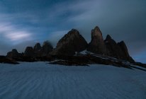 Paisagem fria sombria de montanhas rochosas no vale branco de neve contra o céu estrelado mágico em Dolomites, Itália — Fotografia de Stock